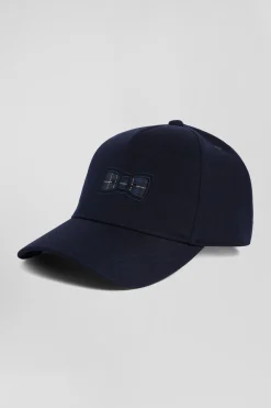 Navy blue cap with bow tie emblem