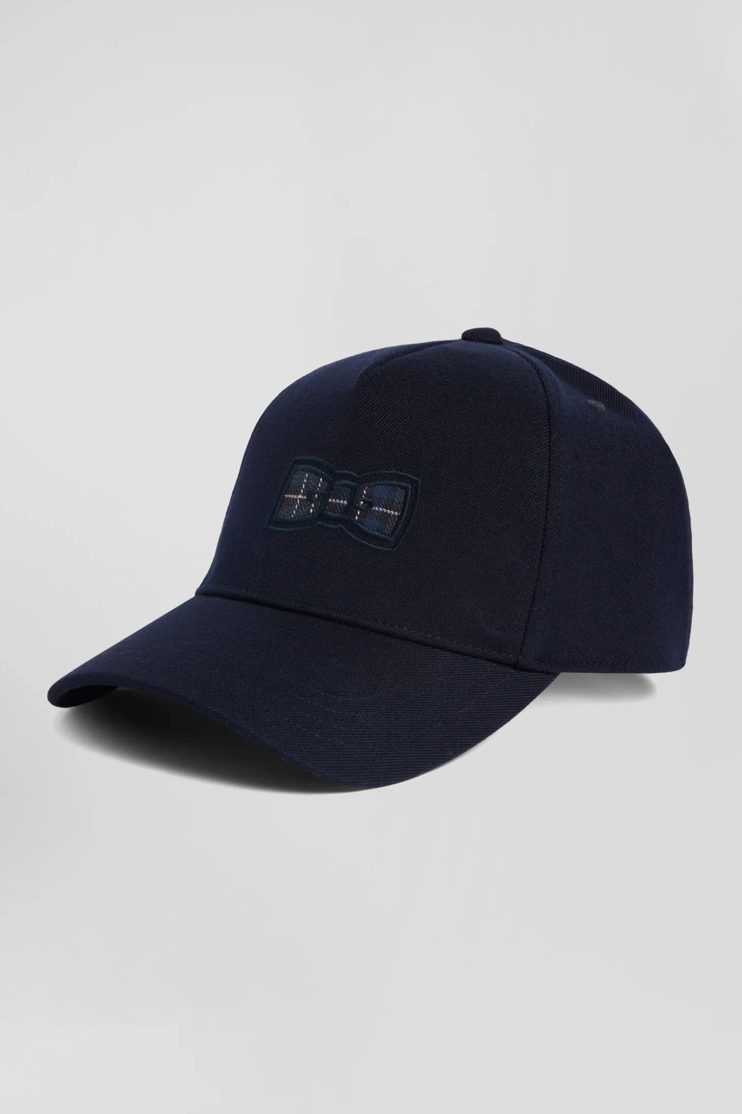 Navy blue cap with bow tie emblem