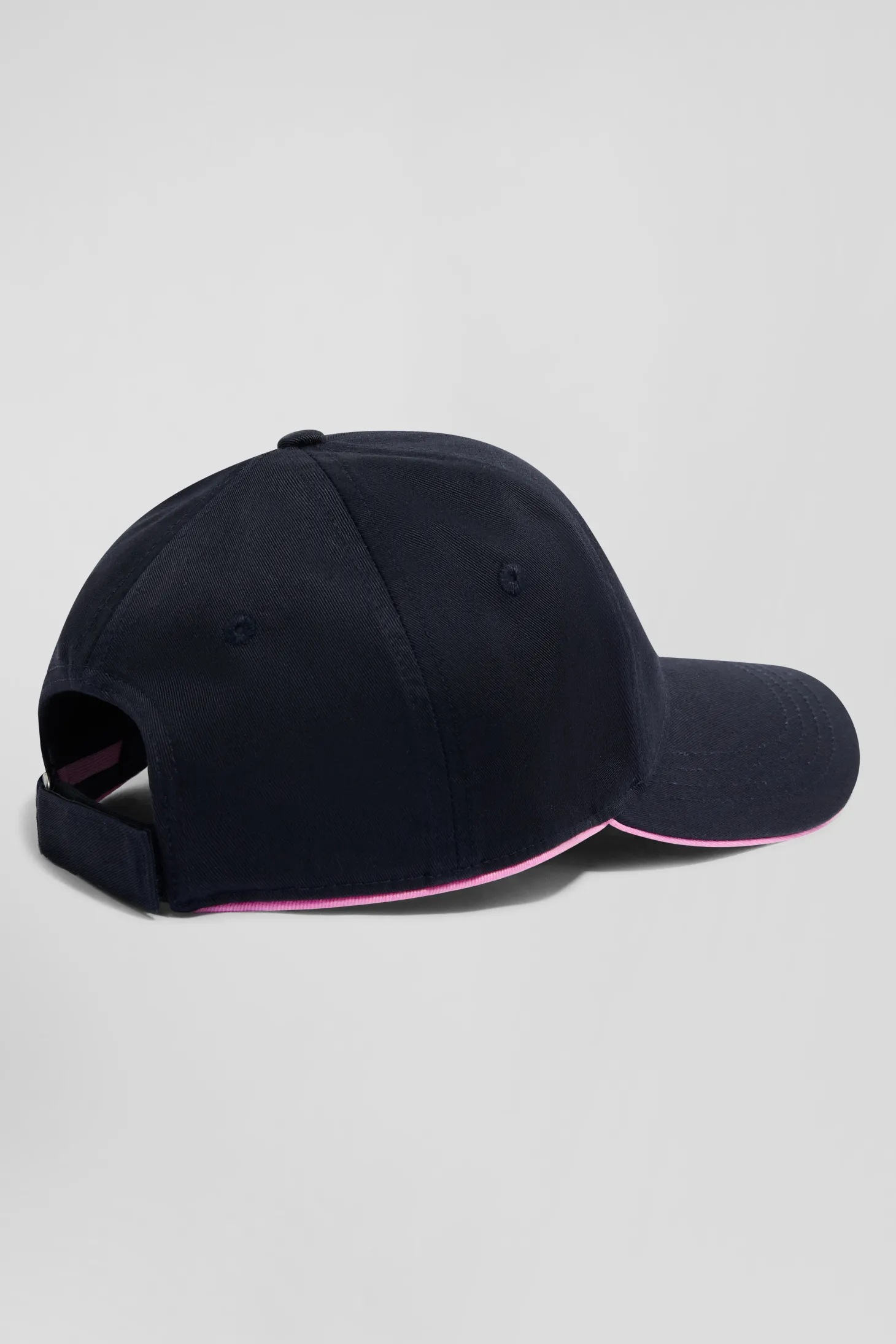 Navy blue cotton cap with bow tie badge and pink piping