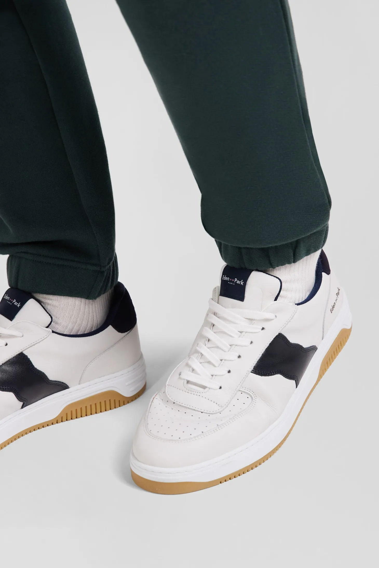 White low-top leather sneakers with navy blue cut-out