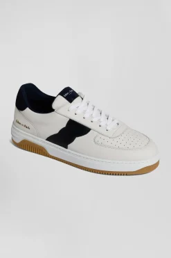 White low-top leather sneakers with navy blue cut-out