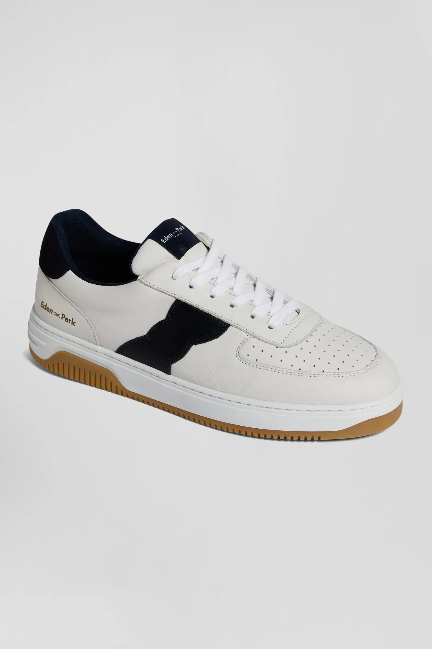 White low-top leather sneakers with navy blue cut-out