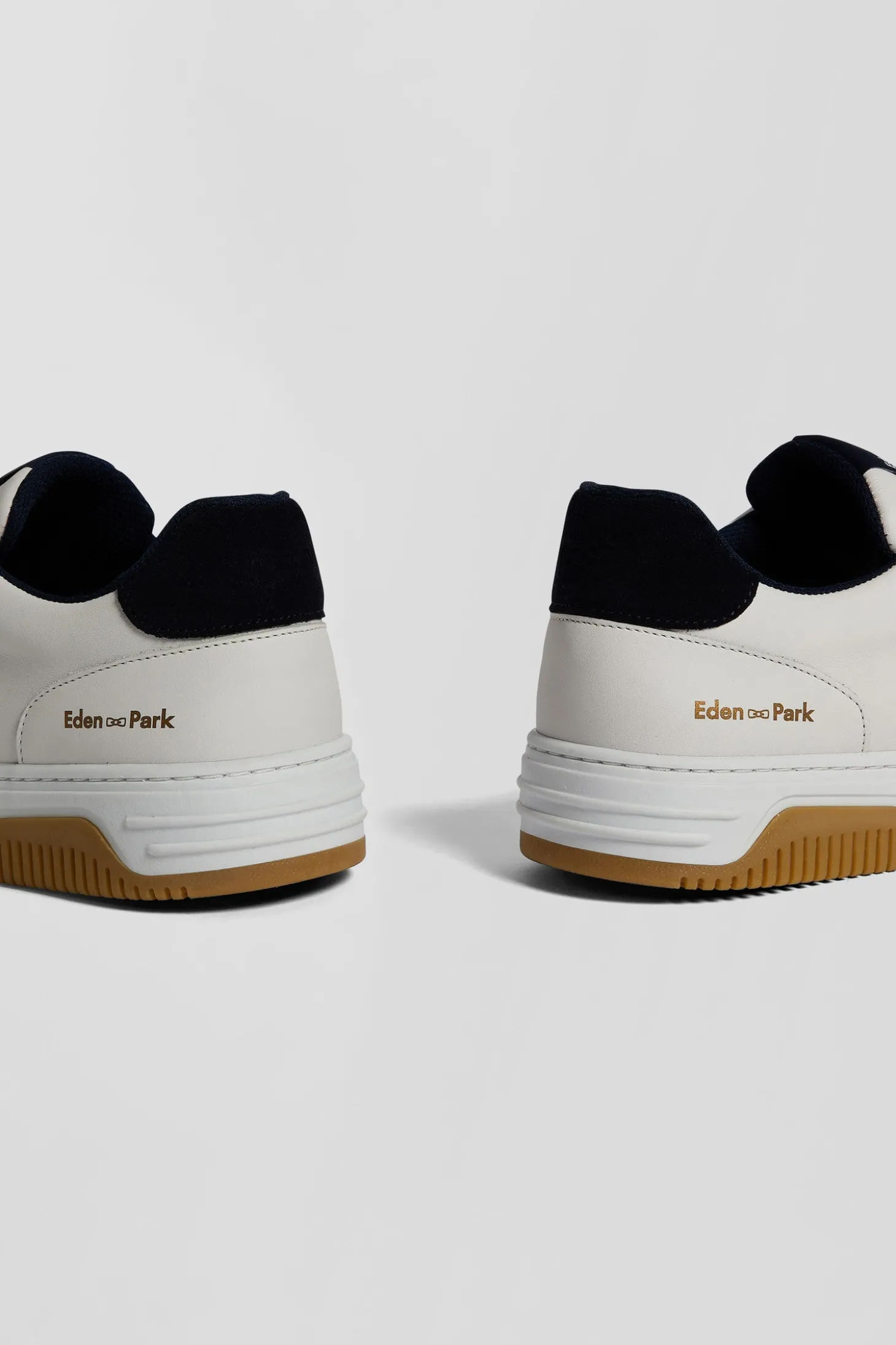 White low-top leather sneakers with navy blue cut-out